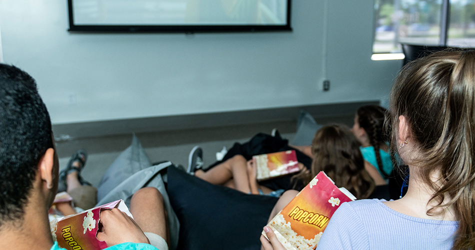 Jeunes qui écoutent un film en mangeant du pop corn