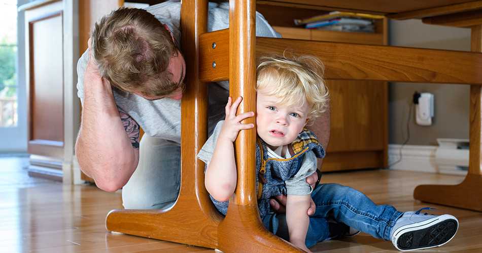 Homme et enfant réfugiés sous une table