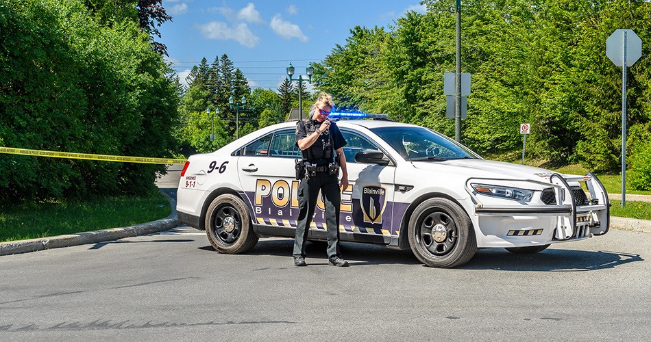Policière devant une voiture de police