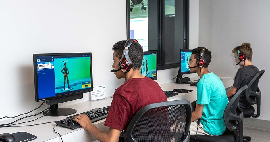 Trois jeunes garçons jouant à un jeu en ligne sur leur ordinateur